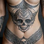 tete de mort tatouée sur le ventre d'une femme